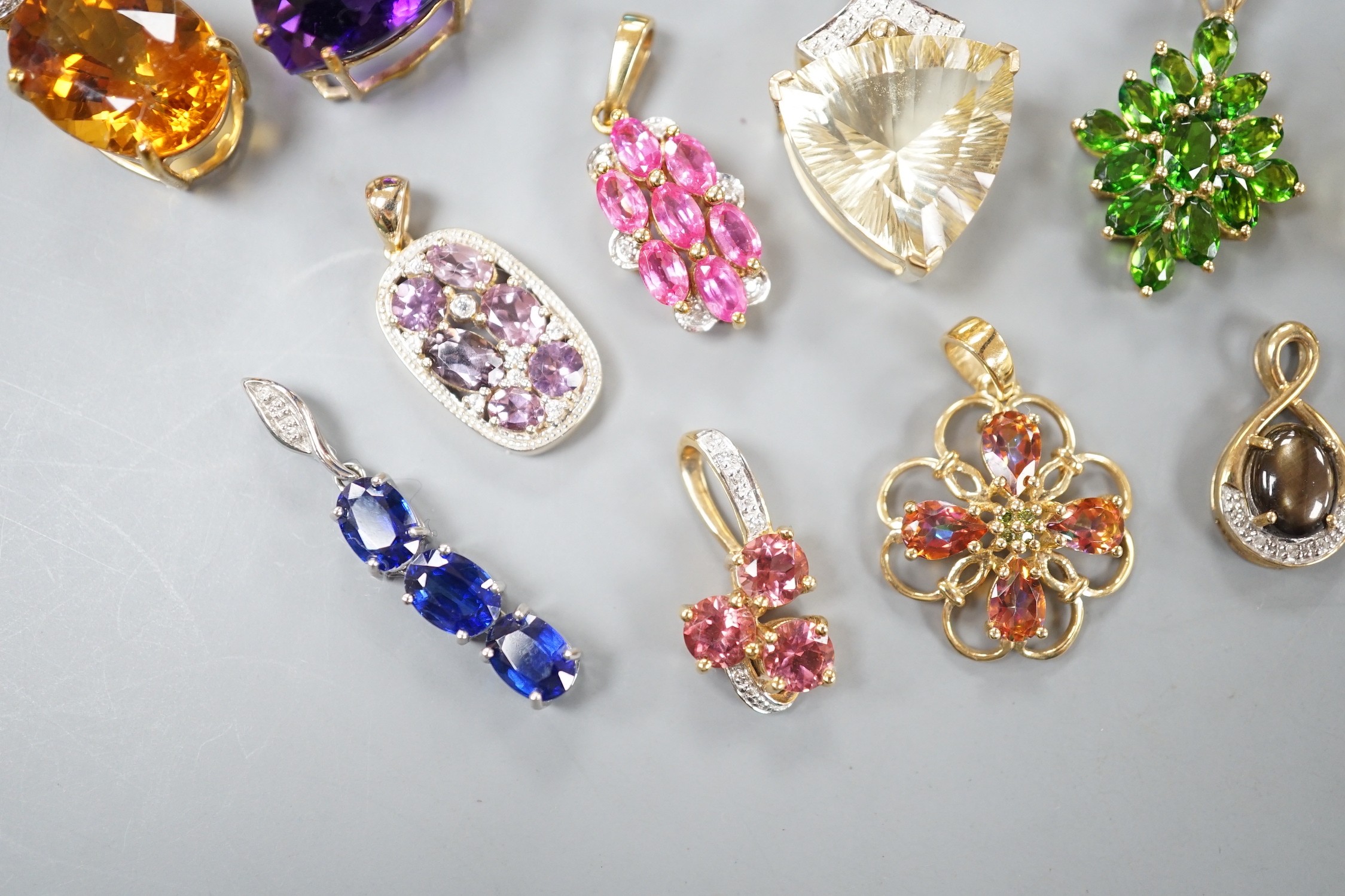 Nineteen assorted modern 9ct gold or yellow metal and gem set pendants, including citrine and amethyst and a 9ct gold chain, gross weight 63.6 grams.